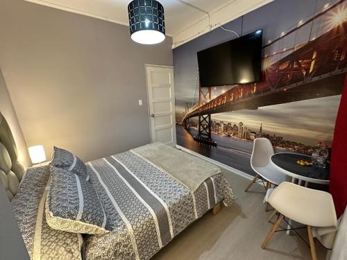 um quarto com uma cama e uma televisão na parede em New York Suites em Viña del Mar