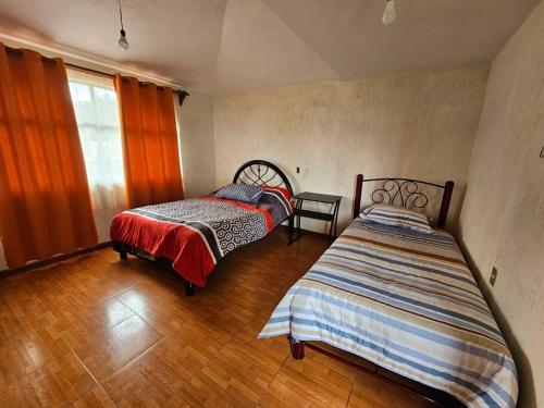 1 dormitorio con 2 camas y ventana en Casa completa a 10 min de Teziutlan., 
