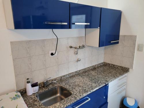 a kitchen with blue cabinets and a sink at Casa Carlos Paz a los pies de la montaña in Villa Carlos Paz