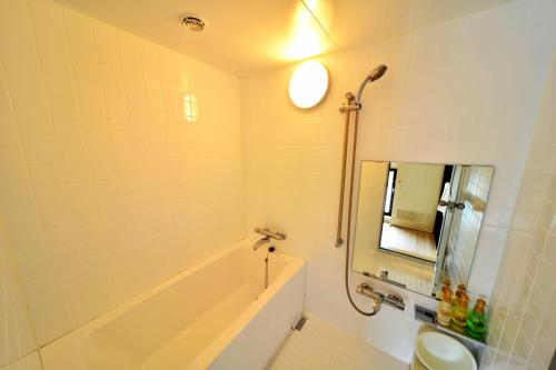 a bathroom with a tub and a toilet and a sink at Kushiro Century Castle Hotel in Kushiro