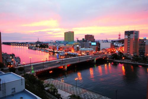 a city with a bridge over a river at night at Kushiro Century Castle Hotel in Kushiro