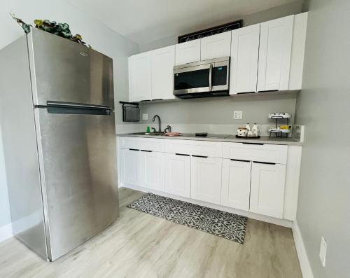 a kitchen with white cabinets and a stainless steel refrigerator at Casita Guayaba in Miami