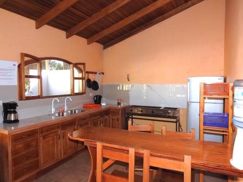 uma cozinha com uma mesa, um lavatório e um fogão em Osa House - Drake Bay em Drake
