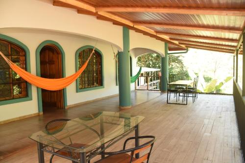a room with a glass table and chairs on a patio at Osa House - Drake Corcovado Tours in Drake