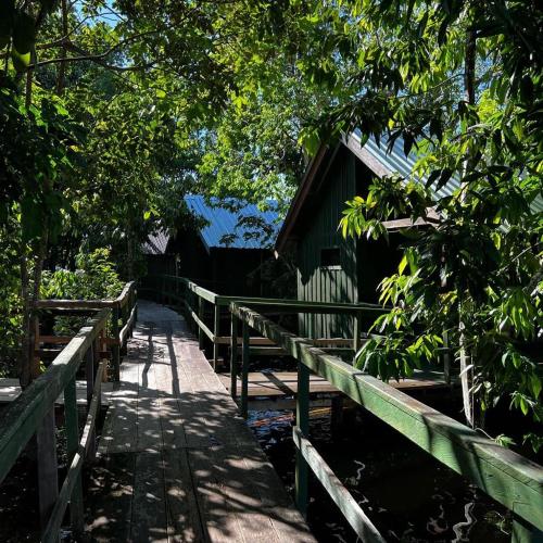 a wooden path leading to a cabin with a fence at Amazônia LODGE Exxperience in Manaus