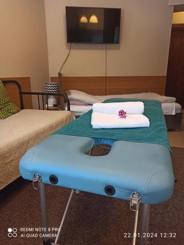 a room with two beds and a table with towels at 3-Studio in Poznań