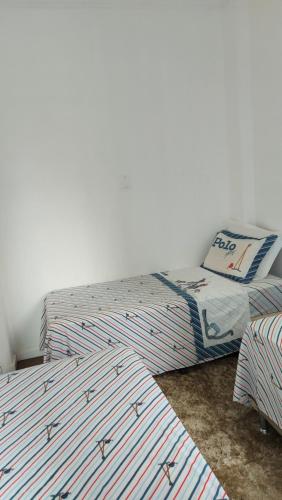 duas camas de solteiro num quarto com a ritualidade de ritismo cristão de ritismo cristão de cristianismo em Apartamento no Flamengo, excelente localização. no Rio de Janeiro