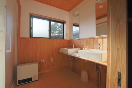 a bathroom with two sinks and two mirrors at 古民家一棟貸 太田邸 in Yazu