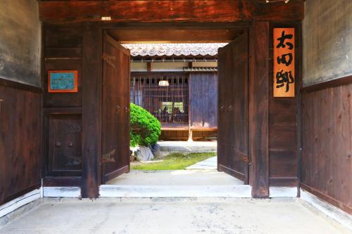 an entrance to a building with an open door at 古民家一棟貸 太田邸 in Yazu