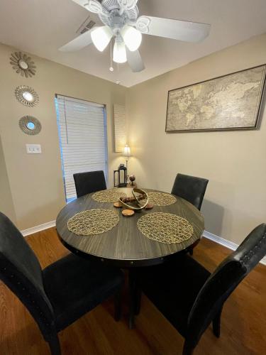 a dining room table with chairs and a ceiling fan at Bayou and Beyond: The perfect stay in Monroe