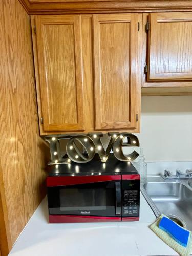 a red microwave sitting on top of a kitchen counter at Bayou and Beyond: The perfect stay in Monroe