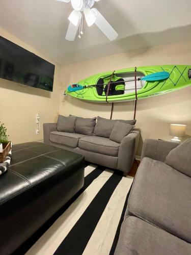 a living room with a couch and a kayak on the wall at Bayou and Beyond: The perfect stay in Monroe