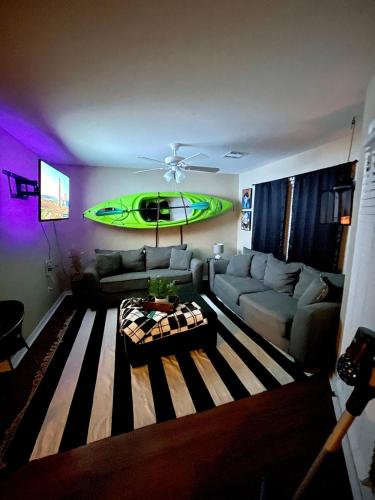 a living room with a couch and a surfboard on the wall at Bayou and Beyond: The perfect stay in Monroe
