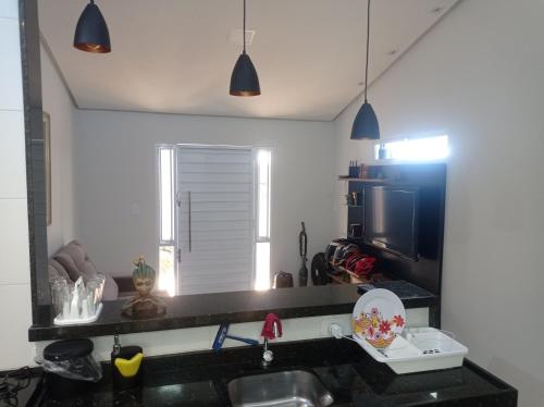 eine Küche mit einer Spüle und einer Mikrowelle in der Unterkunft Casa de Esquina Nova in Garanhuns