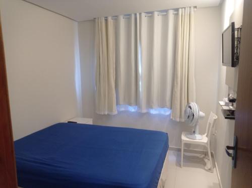 um quarto com uma cama azul e uma janela em Casa de Esquina Nova em Garanhuns