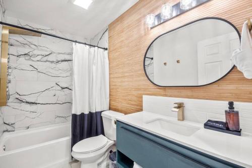 a bathroom with a toilet and a sink and a mirror at Delight: Bold & Bougie! Sleeps 12! Downtown Boyne in Boyne City