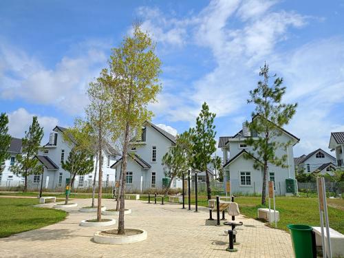 einem Park mit Bäumen und Bänken vor einem Gebäude in der Unterkunft EV Sweet Holiday Homestay in Malakka