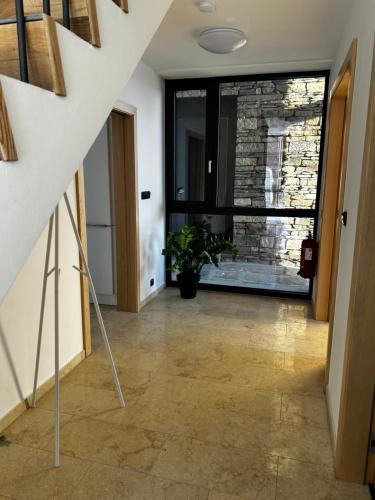 a hallway with a stone wall and a staircase with a window at Palace Resort Jíloviště in Jíloviště