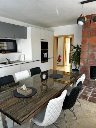 a kitchen and dining room with a wooden table and chairs at Palace Resort Jíloviště in Jíloviště