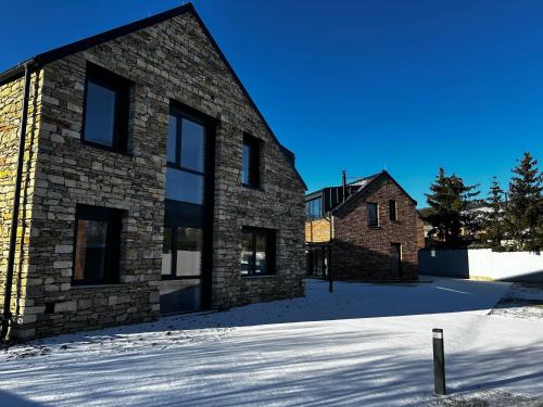 a brick building with snow on the ground at Palace Resort Jíloviště in Jíloviště