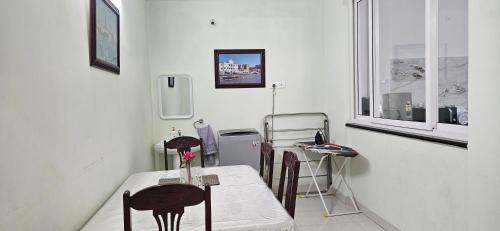 a dining room with a table and chairs and a window at Vazeer Residancy in Hyderabad
