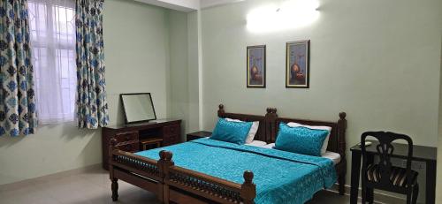 a bedroom with a bed with a blue comforter at Vazeer Residancy in Hyderabad