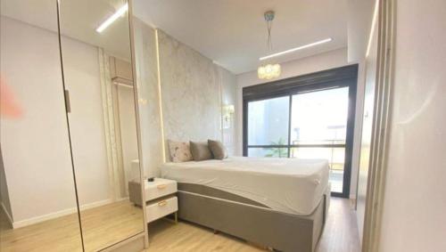 a bedroom with a bed and a glass wall at Cobertura Palmas in Governador Celso Ramos