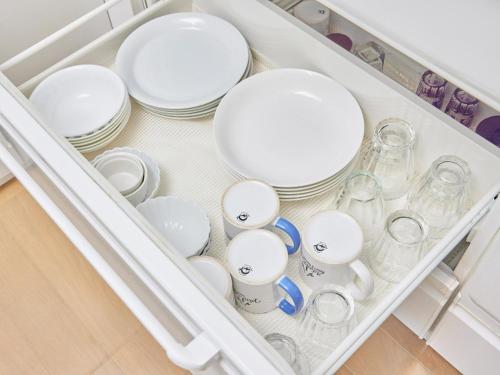 un tiroir rempli d'assiettes, de tasses et de vaisselle dans l'établissement Villa AdanRose Amami - Vacation STAY 06112v, à Amami