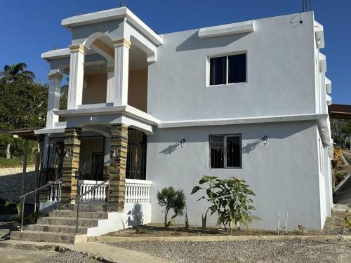 a white house with some stairs in front of it at Villa Richie's House RD. 