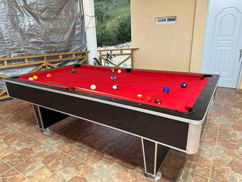 a red pool table with balls on top of it at Villa Richie's House RD. 
