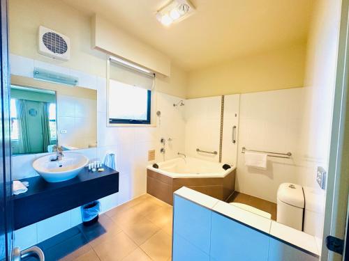 ein Badezimmer mit einer Badewanne, einem Waschbecken und einer Badewanne in der Unterkunft Comfort Inn & Suites City Views in Ballarat