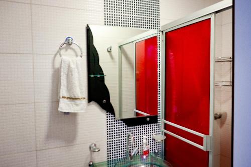 a bathroom with a red door and a mirror at CASA GOMEZ in Leticia