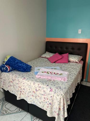 a bed with two boxes on top of it at Quarto em casa familiar in São Gabriel