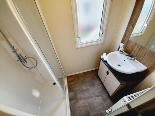 uma pequena casa de banho com um lavatório e um chuveiro em Beautiful 8 Berth Caravan At Valley Farm Holiday Park, Essex Ref 46362v em Great Clacton