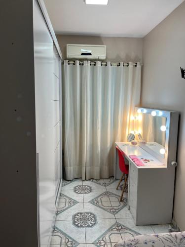 a bathroom with a desk and a shower with a mirror at Quarto em casa familiar in São Gabriel