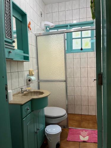 a bathroom with a toilet and a sink at Quarto em casa familiar in São Gabriel