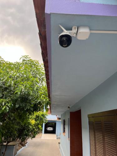 una cámara de seguridad en el lateral de un edificio en Quarto em casa familiar en São Gabriel