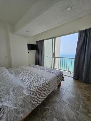 a bedroom with a bed and a large window at Apartamento Torres gemelas in Acapulco