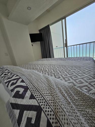 a bedroom with a bed and a large window at Apartamento Torres gemelas in Acapulco