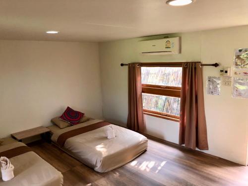 a small room with a bed and a window at โฮมสเตย์ตานงค์ อำเภอปัว in Nan