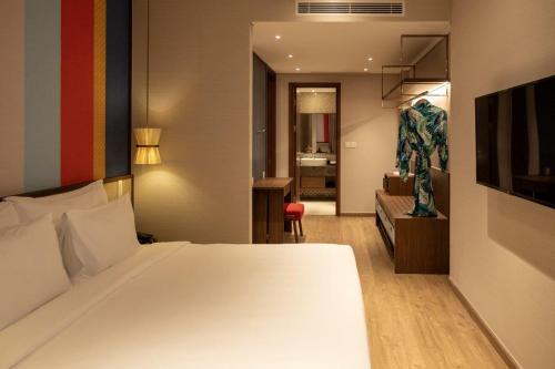 a hotel room with a bed and a bathroom at M Continental by Mandala Mui Ne in Phan Thiet