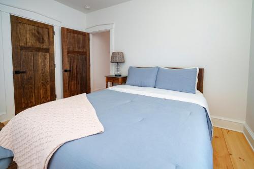 a blue bed in a white room with a blue bedspread at Very Cozy, 2 Bedroom Farmhouse Apartment 2nd FL in Lancaster