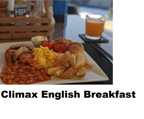 a plate of food with meat and potatoes and a glass of beer at Absolute Bangla Suites in Patong Beach