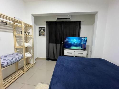 um quarto com uma televisão e uma cama com um cobertor azul em Casa com 03 quartos proximo a rodoviaria em Uruguaiana