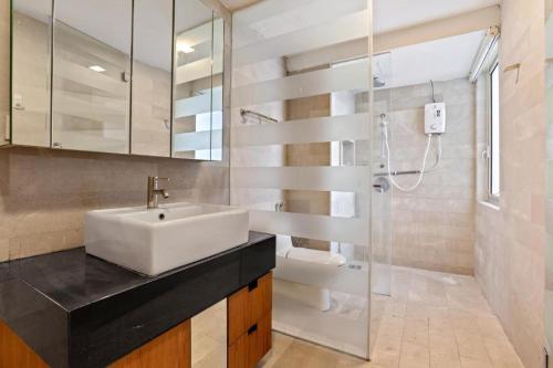 y baño con lavabo blanco y ducha. en MyHabitat KL by Plush Services, en Kuala Lumpur