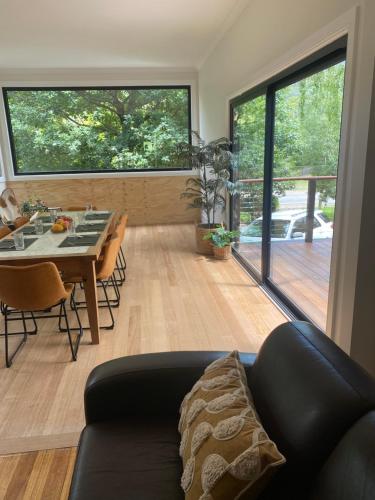 a living room with a black couch and a table at High Country Retreat in Jamieson
