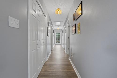 a hallway of a home with white walls and wood floors at Waterfront Home with Pool, Hot Tub and Game Area in Shoreline Park