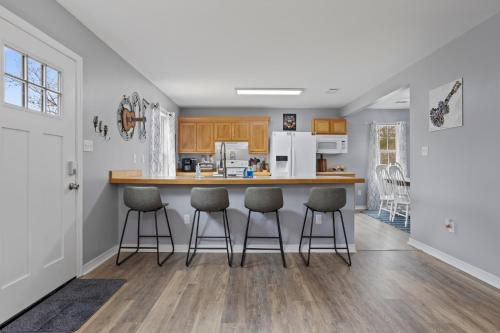 a kitchen with a counter and bar stools at Waterfront Home with Pool, Hot Tub and Game Area in Shoreline Park