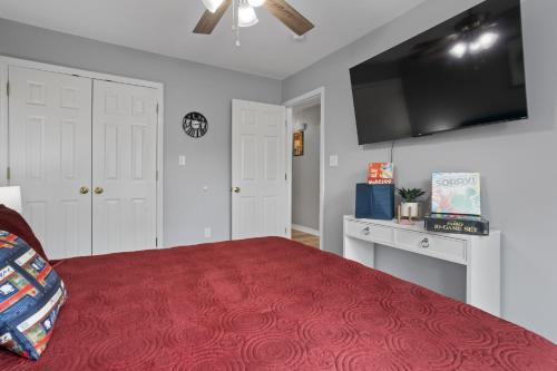 a bedroom with a bed and a flat screen tv at Waterfront Home with Pool, Hot Tub and Game Area in Shoreline Park