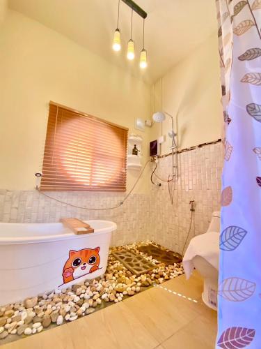 a bathroom with a toilet and a bath tub and rocks at Zoo Villa บ้านน้องแมว in Nan